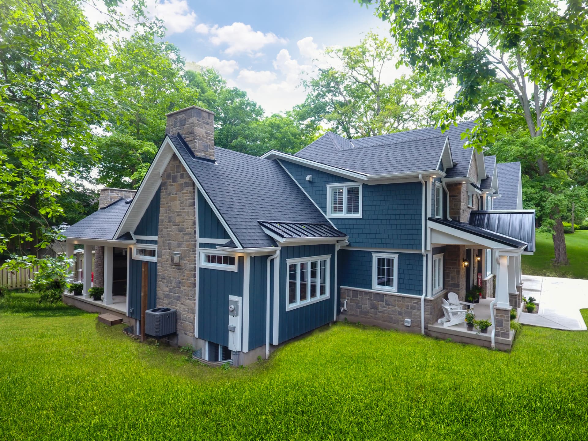 Blue board-and-batten home exterior with stone chimney